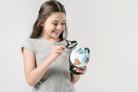 Junior girl studying globe loupe