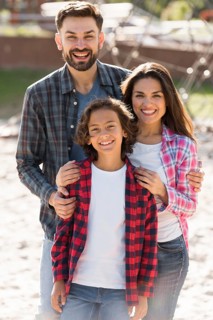 Front view parents with child posing while outdoors