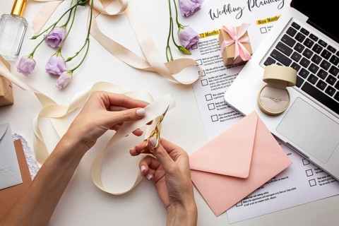 Feminine hands creating handmade invitations