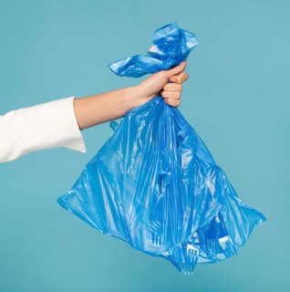 Woman holding blue plastic trash bag