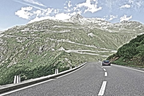 Photo with reduced dynamics saturation HDR of mountain pass alpine mountain road alpine road pass road pass view from Furka road to Furka pass in the background serpentines above tree line