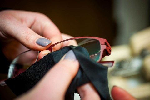 A woman cleans a pair of glasses