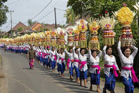 Procession of traditionally dressed women carrying temple offerings
