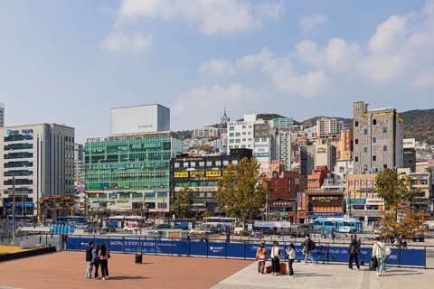 Station forecourt with high-rise buildings and shops