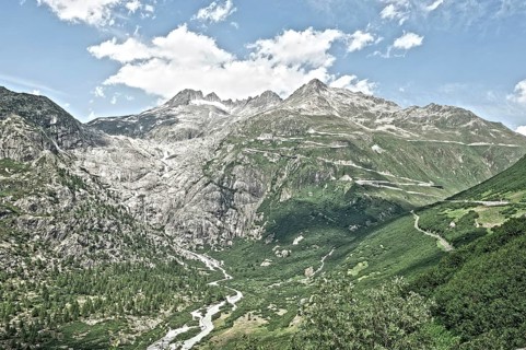 Photo with reduced dynamic saturation HDR of view on in the background Rhone glacier in front river Rotten Rhone right mountain pass alpine mountain road alpine road road pass road pass on Furka Furka...