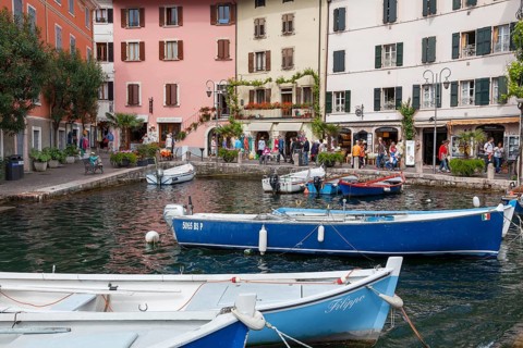 Houses and fishing boats in the old harbour of Limone sul Garda