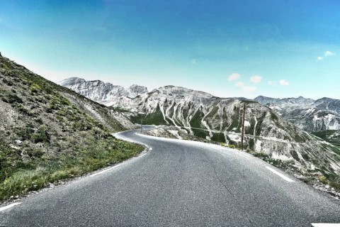 Photo with reduced dynamic range saturation HDR of mountain pass alpine mountain road alpine road pass road pass Col de Raspaillon in French Alps High Alps in high mountains above tree line