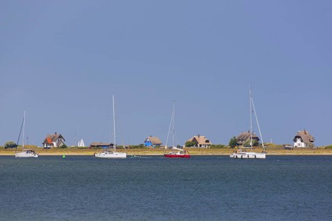 Sailing boats and beach houses along the Baltic Sea on the peninsula Graswarder