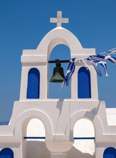 White bell tower with Greek flags