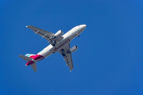 Passenger aircraft of the airline Eurowings in flight with extended landing gear