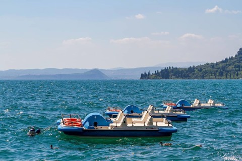 Three pedal boats anchored on Lake Garda