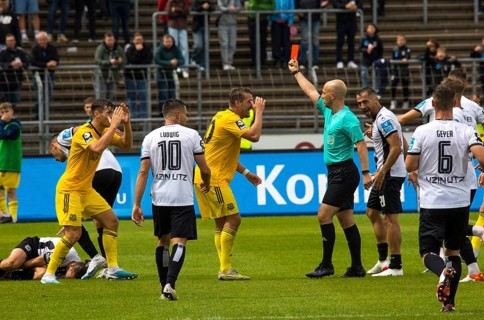 Referee Nicolas Winter shows the red card to player Luca KERBER left