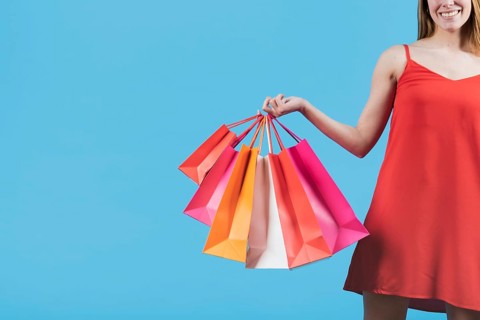 Girl with shopping bags plain background