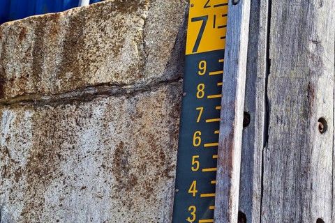 Water level gauge in the harbour basin at high tide and flood