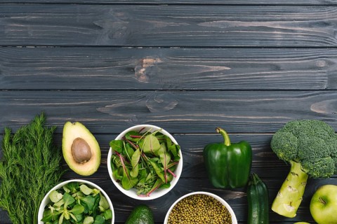 Green fresh vegetables black wooden desk