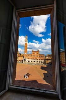 Spring clouds over the Piazza del Campo with the bell tower Torre del Mangia and the town hall Palazzo Pubblico