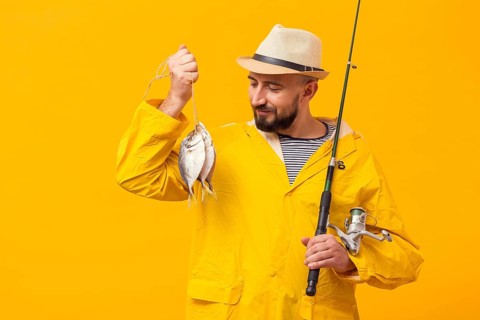 Front view proud fisherman holding catch fishing rod