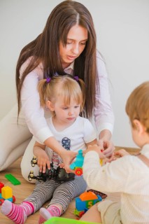 Brunette woman playing with kids