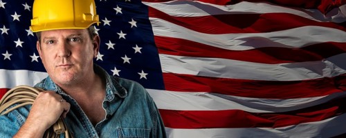 Male contractor wearing blank yellow hardhat over waving american flag background banner