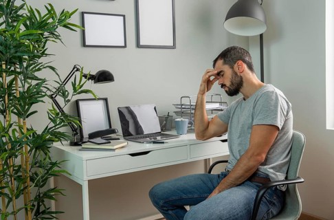 Tired man sitting his home desk