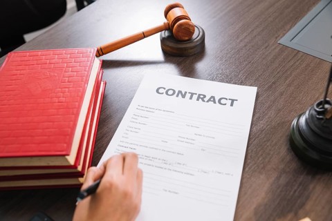 Person writing document table with books gavel