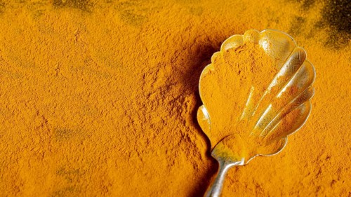 Top view spoon with turmeric with copy space