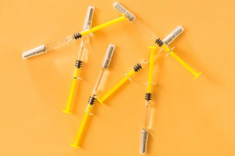 Elevated view medical syringes yellow background