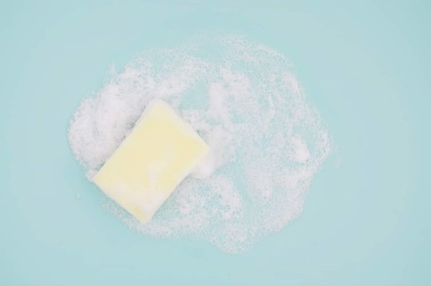Overhead view sponge with sud blue background