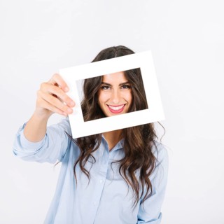 Joyful woman holding frame front face