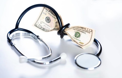 Stethoscope tied with dollar bills. High cost of medical health with stethoscope. Stethoscope wrapped around money isolated