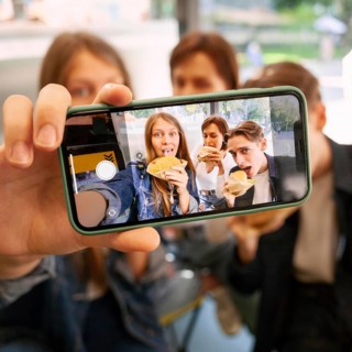 Group friends taking selfie together while eating fast food