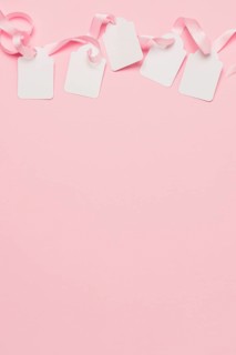 White tags pink ribbon top background with space text