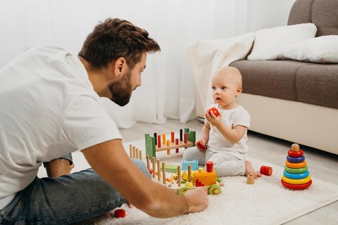 Father teaching baby play with toys