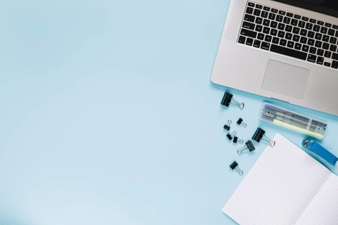 Elevated view laptop stationeries blue backdrop