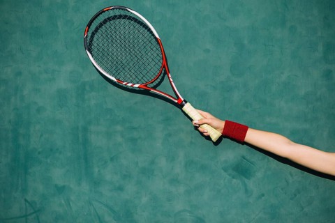 Woman holding tennis racket hand