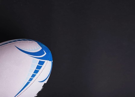 Close up white rugby ball black background