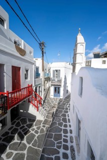 Cycladic Greek Orthodox Church and white houses with colourful doors