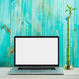 Laptop with blank white screen wooden desk