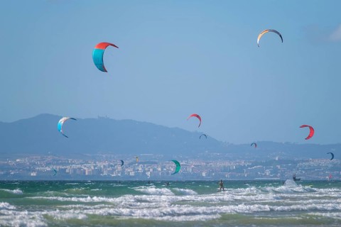 Kiteboarding kitesurfing kiteboarder kitesurfer kites on the Atlantic ocean beach at Fonte da Telha beach