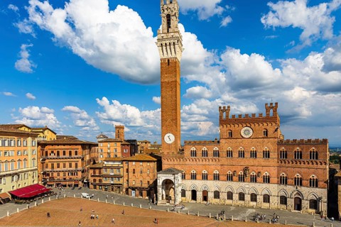 Spring clouds over the Piazza del Campo with the bell tower Torre del Mangia and the town hall Palazzo Pubblico