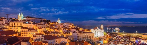 Panorama of Lisbon famous view from Miradouro de Santa Luzia tourist viewpoint over Alfama old city district at night. Lisbon