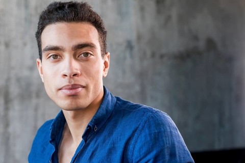 Close up young man looking camera against grey wall