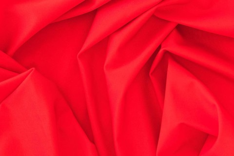 Folded red textile fabric texture background