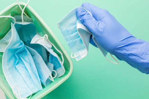 Person wearing protection gloves taking disposable mask