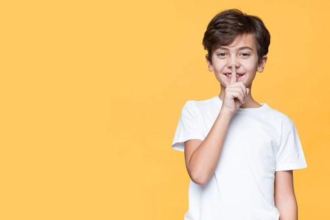 Young boy showing sign silence