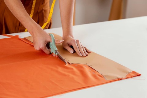 Close up hands cutting fabric
