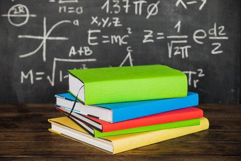 Books desktop near chalkboard