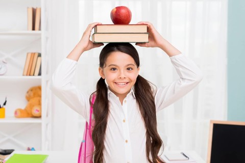 Ethnic schoolgirl holding books head