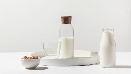 Front view milk bottle with walnuts tray