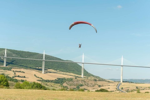 Paraglider in front of the Millau Bridge. Grands Causses